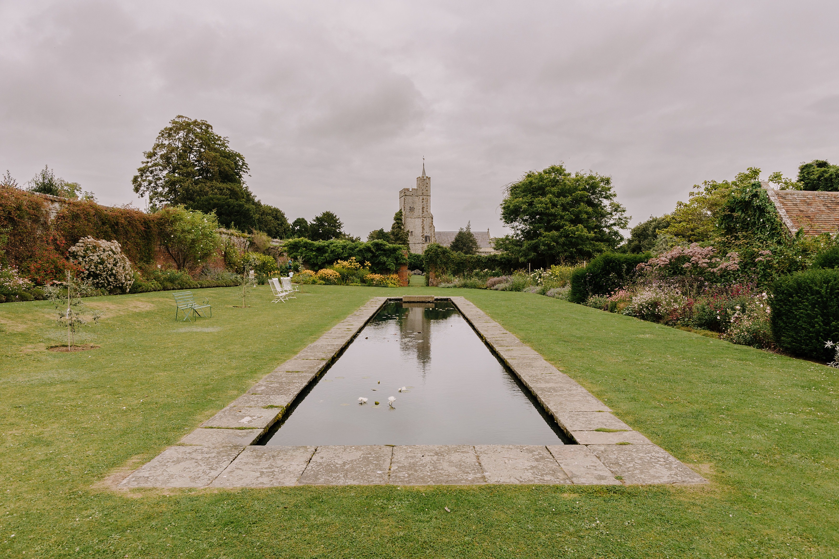 Ornamental pond in the walled garden with The Church of Holy Cross in the background