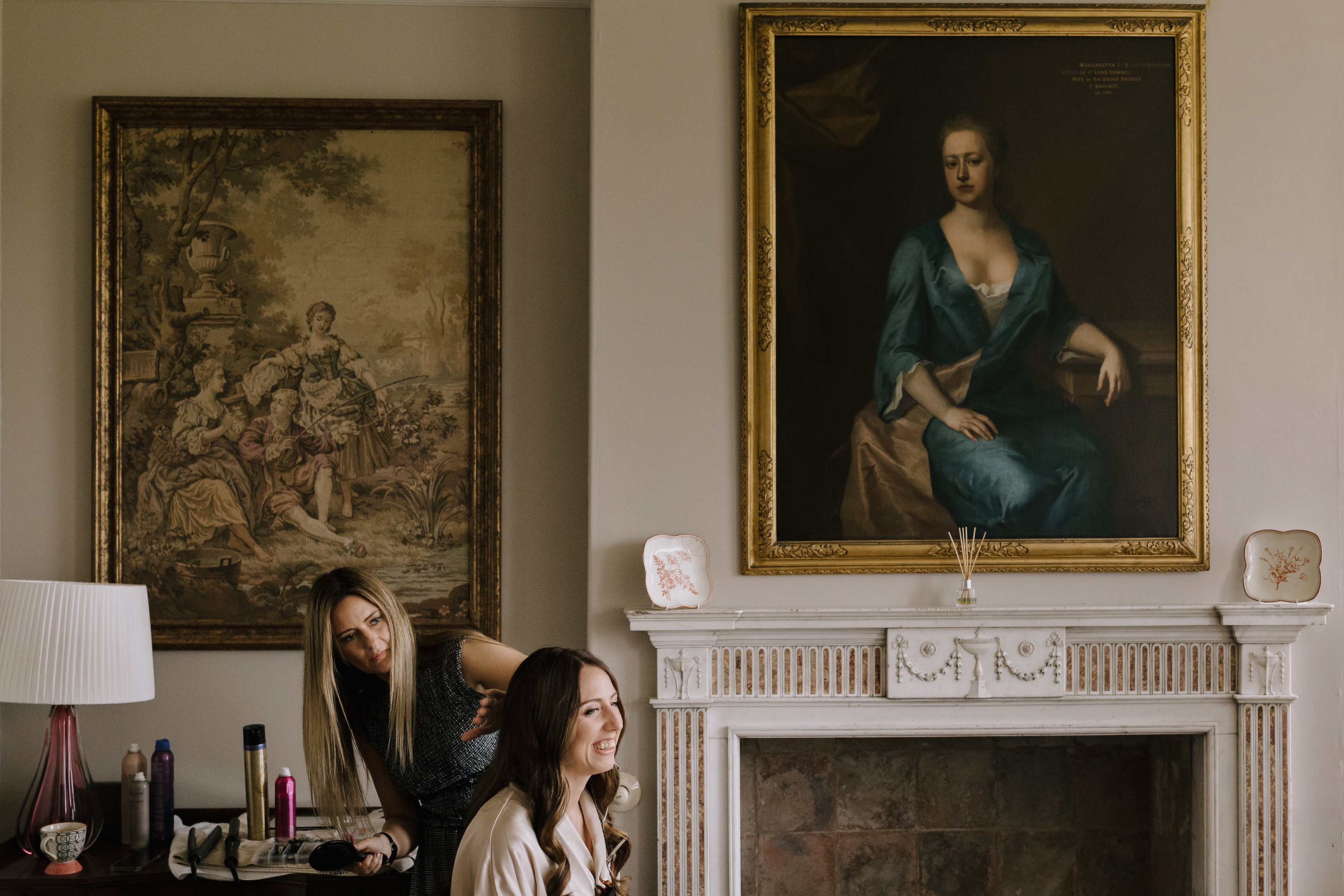 Bride having her hair finished in front of Goodnestone House paintings