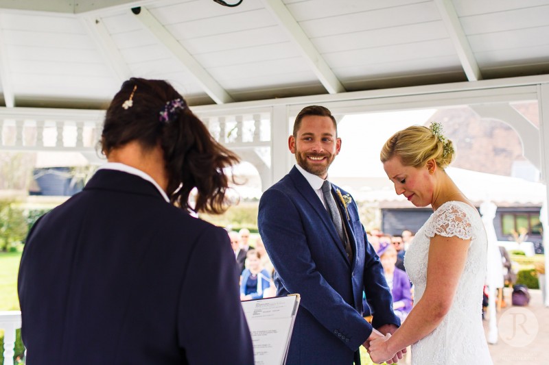 Bride crying as her groom smiles happily