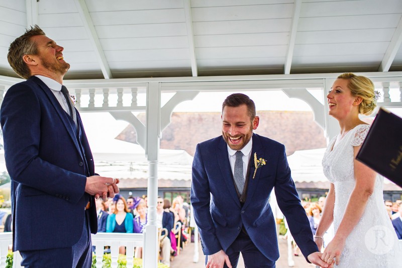 Bestman, groom and bride laughing hard during the ceremony