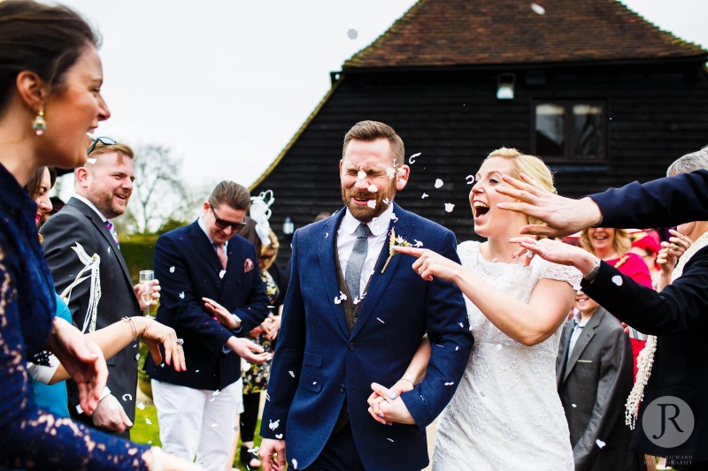 Photograph of couple having confetti thrown in their faces