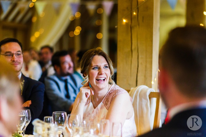 Sister of the bride laughing during speech