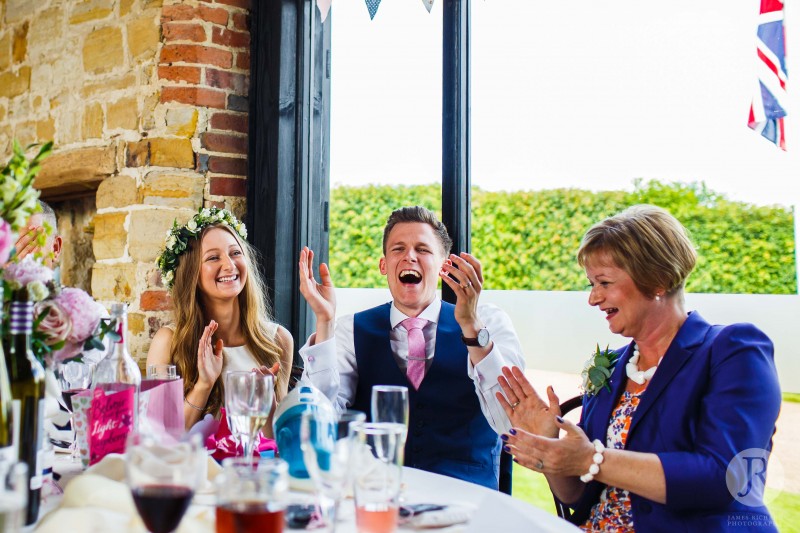 Bride and groom laughing during the bestman speech at the wedding reception