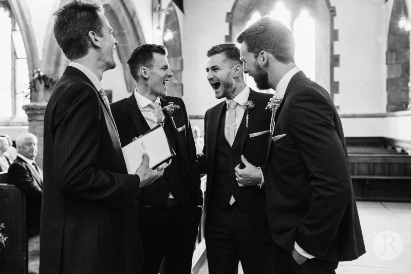 Groom and his friends laughing before the ceremony at All Saints Church