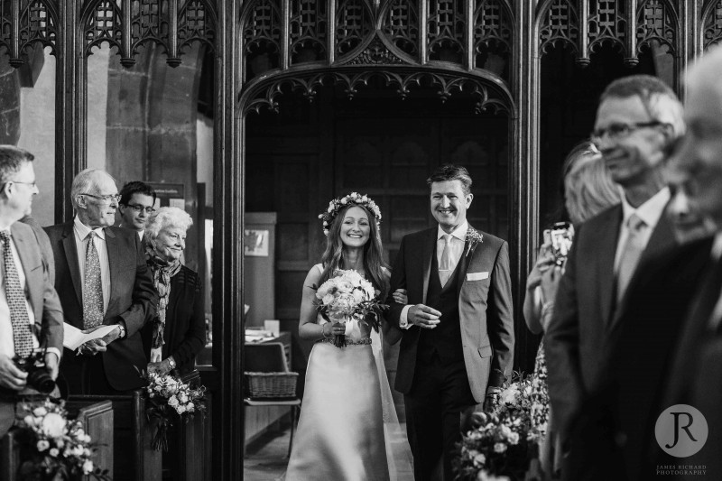 Bride and her dad walking down the aisle smiling