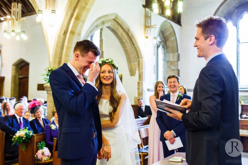 Groom laughing during the vicar's talk