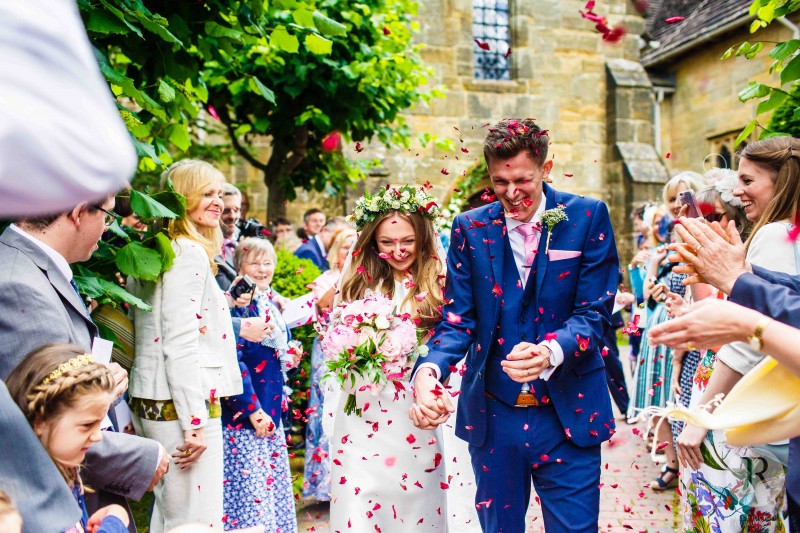 Bride and groom get lots of confetti thrown at them